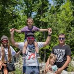 A joyful family enjoying a sunny day outdoors, captured in a lively and happy moment.